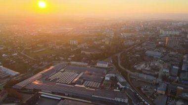 Sanayi binasının çatısına yeşil ekolojik elektrik üretmek için monte edilmiş mavi fotovoltaik panelli güneş enerjisi santralinin hava görüntüsü. Sürdürülebilir enerji konsepti üretimi