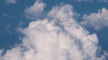 Dünya 'nın yüksek irtifasındaki uçak penceresinden hava manzarası beyaz kabarık kümülüs bulutlarıyla kaplı.