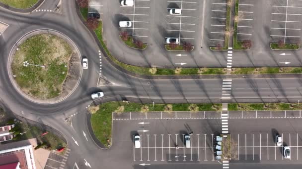 Letecký pohled na mnoho barevných aut zaparkovaných na parkovišti s čárami a značkami pro parkovací místa a směry — Stock video