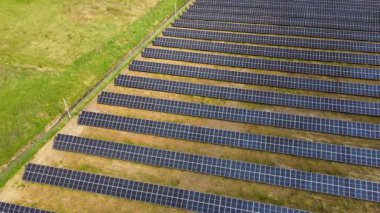 Yeşil alandaki güneş enerjisi santralinin havadan görüntüsü. Temiz ekolojik enerji üretmek için panelleri olan elektrik çiftliği