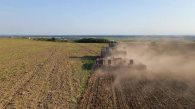 Tarım tarlasını süren traktörün havadan görünüşü yaz mevsiminde tohum ekmek için toprağı hazırlıyor.