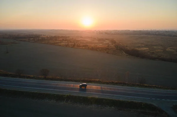 Vista aérea de la carretera interurbana con coche de conducción rápida borrosa al atardecer. Vista superior desde el dron del tráfico por carretera en la noche — Foto de Stock