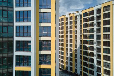 Birçok pencere ve balkonu olan modern yüksek apartman cephesinin mimari ayrıntıları