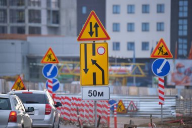 Yol çalışmaları trafik işaretlerini uyardı. Şehir caddesinde inşaat çalışması ve yavaş hareket eden arabalar.
