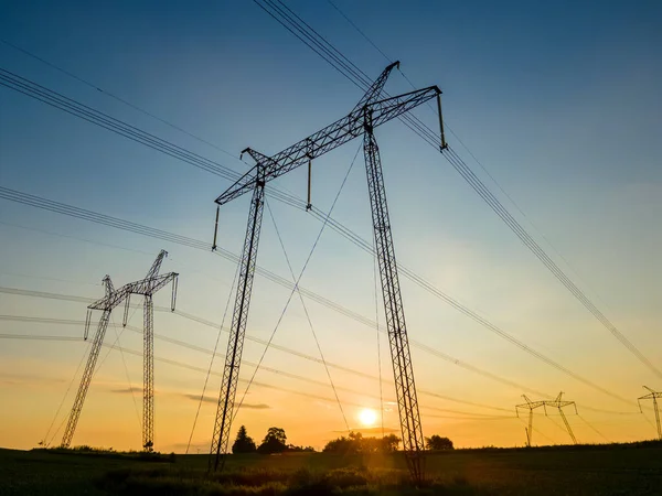 Torri ad alta tensione con linee elettriche al tramonto — Foto Stock