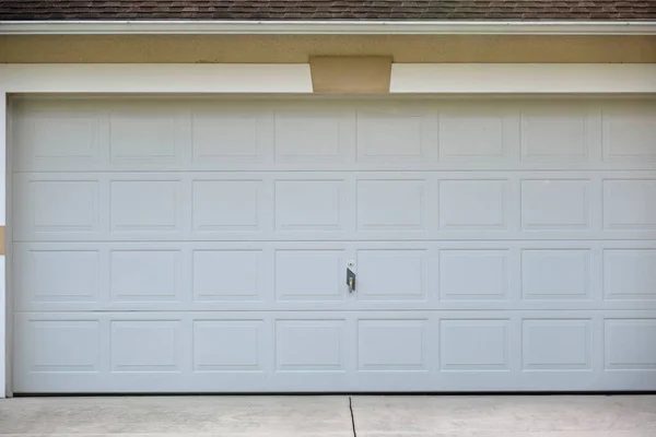 Wide garage double door and concrete driveway of new modern american house — стоковое фото