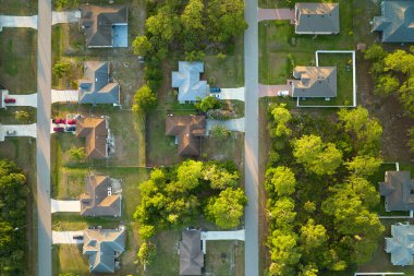 Aerial view of suburban landscape with private homes between green palm trees in Florida quiet residential area
