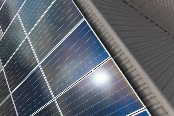 Telhado de construção de vista aérea com fileiras de painéis fotovoltaicos solares azuis para a produção de energia elétrica ecológica limpa. Eletricidade renovável com conceito de emissão zero — Fotografia de Stock