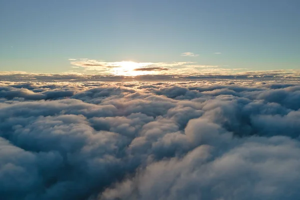 Vista aérea desde arriba a gran altitud de densas nubes de cúmulos hinchados volando por la noche. Increíble puesta de sol desde el punto de vista de la ventana del avión —  Fotos de Stock