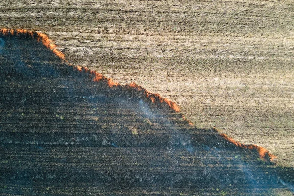乾季に赤い火で燃焼草原フィールドの空中ビュー。自然災害と気候変動の概念 — ストック写真