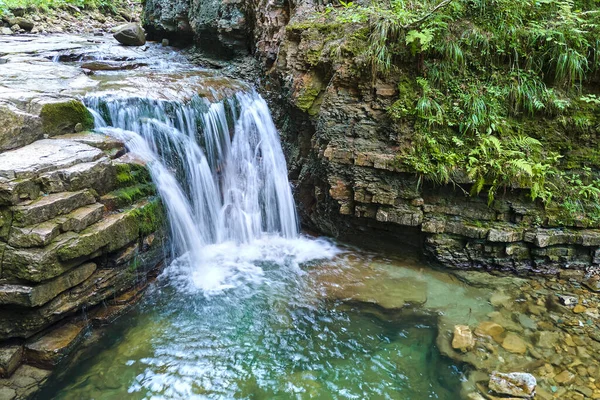 Úžasná krajina krásného vodopádu na horské řece s bílou pěnivou vodou padající z skalnatého útesu v letním deštném pralese — Stock fotografie