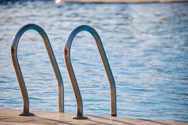 Yüzme havuzuna yakın paslanmaz çelik korkuluklar kaplumbağaların temiz havuz suyuna iniyor. Eğlence etkinlikleri kavramının erişilebilirliği