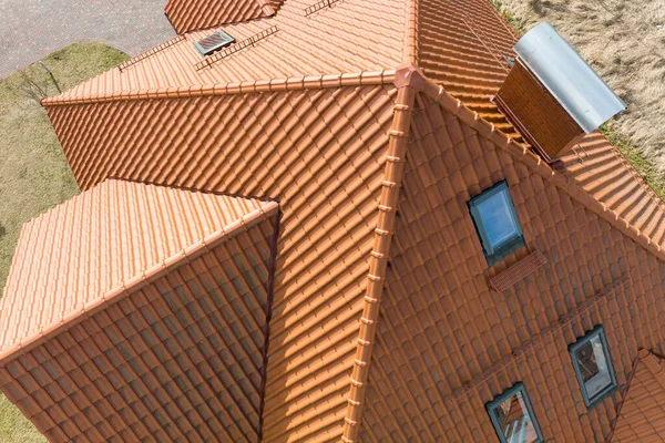 Closeup of attic windows on house roof top covered with ceramic shingles. Tiled covering of building — Photo