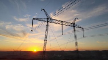 Gün batımında elektrik hatları olan yüksek voltaj kulesi. Elektrik aktarımı