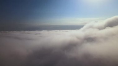Dünya 'nın yüksek irtifasında, yağmur fırtınasından önce oluşan kabarık kümülüs bulutlarıyla kaplı uçak penceresinden hava görüntüsü