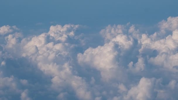 Αεροφωτογραφία από το παράθυρο του αεροπλάνου σε μεγάλο υψόμετρο της γης που καλύπτεται με φουσκωτά σύννεφα που σχηματίζουν σωρός πριν από την καταιγίδα — Αρχείο Βίντεο