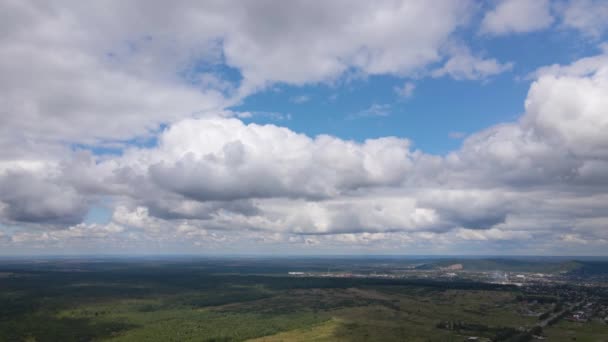Aerial view from high altitude of distant city covered with puffy cumulus clouds forming before rainstorm. Airplane point of view of cloudy landscape — Stock Video