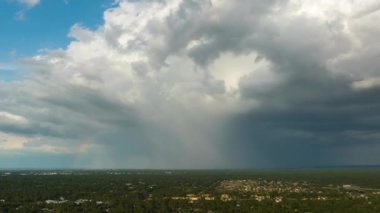 Dark stormy clouds forming on gloomy sky before heavy rainfall over suburban town area