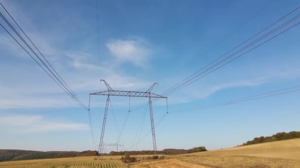 Wieża wysokiego napięcia z liniami elektroenergetycznymi transfekującymi energię elektryczną przez przewody kablowe — Wideo stockowe