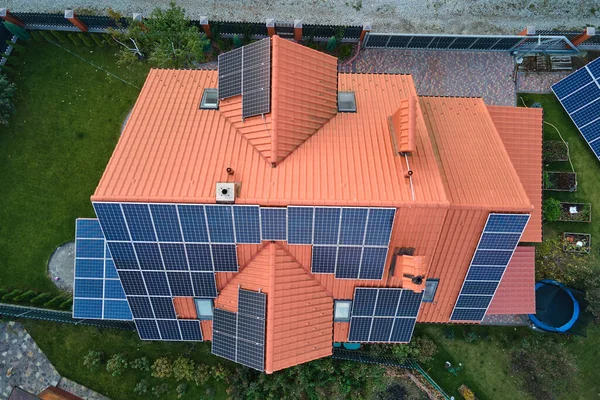 空中景观建筑屋顶与一排蓝色太阳能光电板生产清洁的生态电能。可再生能源，零排放概念 — 图库照片