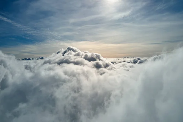 Vista aérea desde la ventana del avión a gran altitud de la tierra cubierta con nubes de cúmulos hinchados blancos —  Fotos de Stock