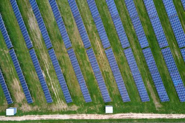 Yeşil alandaki güneş enerjisi santralinin havadan görüntüsü. Temiz ekolojik enerji üretmek için panelleri olan elektrik çiftliği