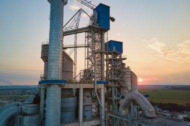 Yüksek fabrika yapısı olan çimento fabrikası ve endüstriyel üretim bölgesinde kule vinçleri var. Üretim, küresel sanayi ve hava kirliliği kavramı