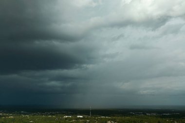 Kasaba üzerinde sağanak fırtınadan önce fırtınalı gökyüzünde oluşan kara uğursuz bulutların manzarası.