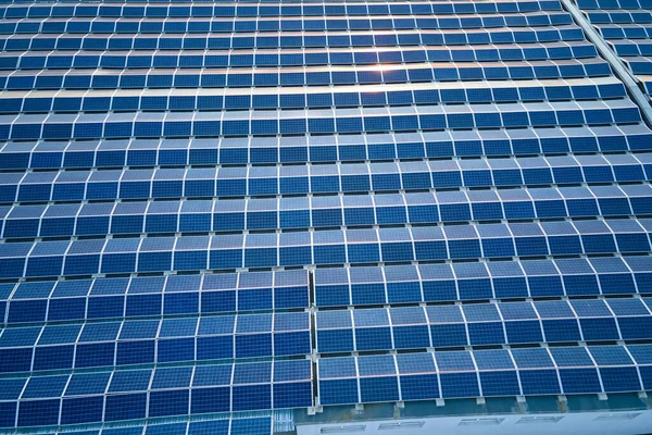 Vista aérea de usina de energia solar com painéis fotovoltaicos azuis montados no telhado de construção industrial para a produção de eletricidade ecológica verde. Produção de conceito de energia sustentável — Fotografia de Stock