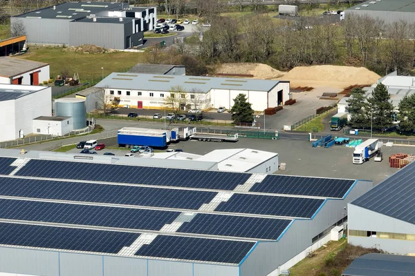 Sanayi binasının çatısına yeşil ekolojik elektrik üretmek için monte edilmiş mavi fotovoltaik panelli güneş enerjisi santralinin hava görüntüsü. Sürdürülebilir enerji konsepti üretimi