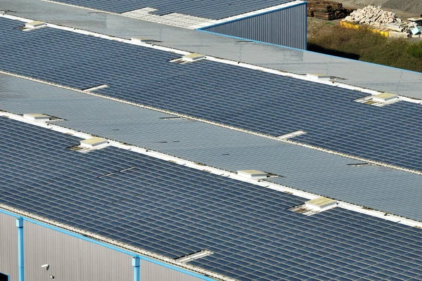 Veduta aerea della centrale solare con pannelli fotovoltaici blu montati sul tetto dell'edificio industriale per la produzione di energia elettrica ecologica verde. Produzione di concetto di energia sostenibile — Foto Stock