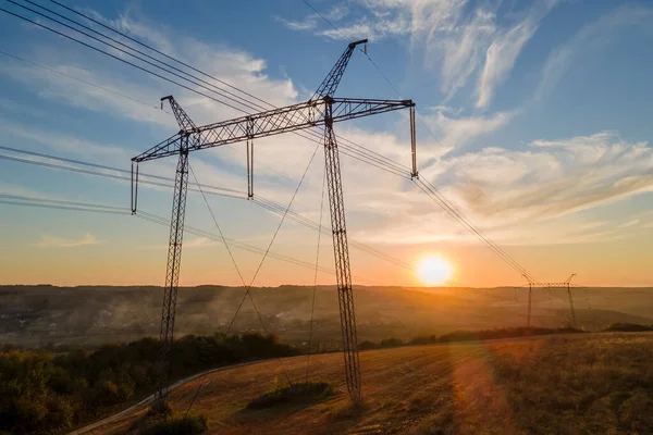 Dunkle Silhouette eines Hochspannungsturms mit Stromleitungen bei Sonnenaufgang. Übertragung des elektrischen Energiekonzepts — Stockfoto