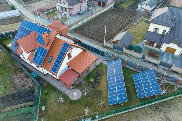 Casa residenziale con tetto coperto con pannelli fotovoltaici solari per la produzione di energia elettrica ecologica pulita in zona rurale suburbana. Concetto di casa autonoma — Foto Stock