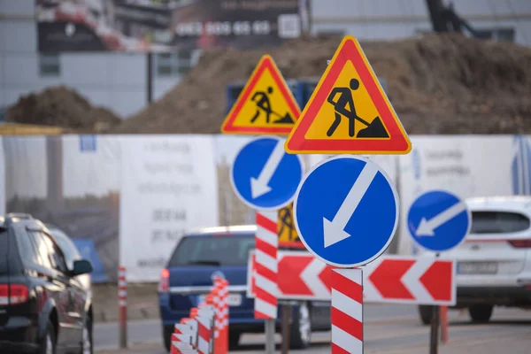 Дорожні роботи попереджають про дорожні знаки будівельних робіт на міській вулиці і повільно переміщують автомобілі — стокове фото