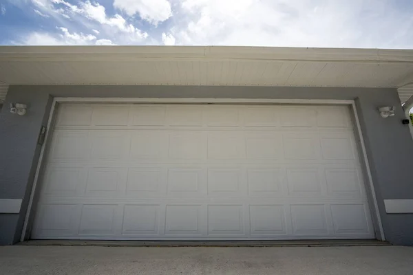 Wide garage double door and concrete driveway of new modern american house — стоковое фото