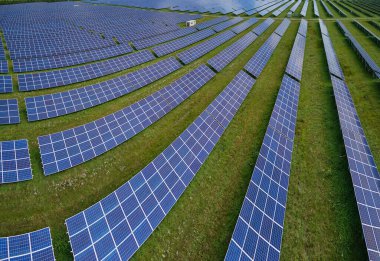 Temiz elektrik enerjisi üretmek için birçok sıra güneş fotovoltaik paneli bulunan sürdürülebilir büyük elektrik santralinin havadan görünüşü. Sıfır emisyon kavramı ile yenilenebilir elektrik