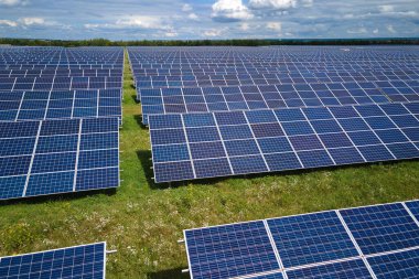 Temiz elektrik enerjisi üretmek için sıra sıra güneş fotovoltaik panelleri olan sürdürülebilir büyük elektrik santralinin havadan görünüşü. Sıfır emisyonlu yenilenebilir elektrik kavramı