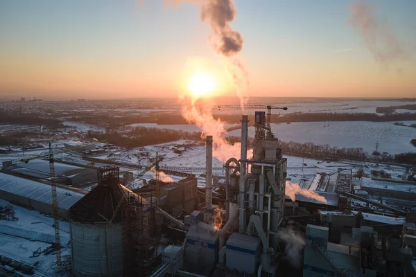 Vue aérienne de la cimenterie avec structure en béton élevé et grue à tour dans la zone de production industrielle en soirée. Fabrication et concept d'industrie mondiale — Photo