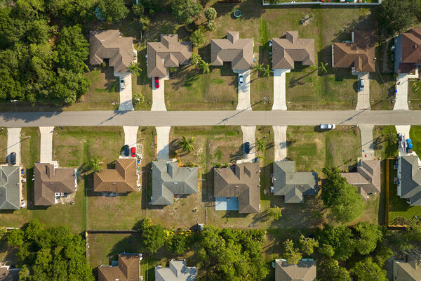 Aerial view of suburban landscape with private homes between green palm trees in Florida quiet residential area.