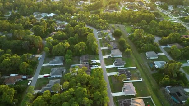 Vista aérea del paisaje de casas privadas suburbanas entre palmeras verdes en la zona rural tranquila de Florida al atardecer — Vídeos de Stock
