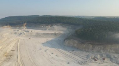 Kazı araçları ve çöp kamyonlarıyla inşaat endüstrisi için kireçtaşı malzemelerinin açık maden sahası görüntüsü