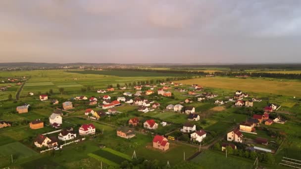 Widok z lotu ptaka na domy mieszkalne na podmiejskich obszarach wiejskich o zachodzie słońca — Wideo stockowe