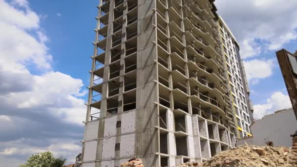 Architectural detail of high frame of monolithic concrete building under construction and old demolished house in front. Real estate development — Stock Video