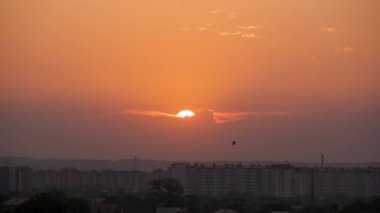 Güneş batarken akşam manzarası Uzak şehrin yüksek binalarının üzerinde gün batımında