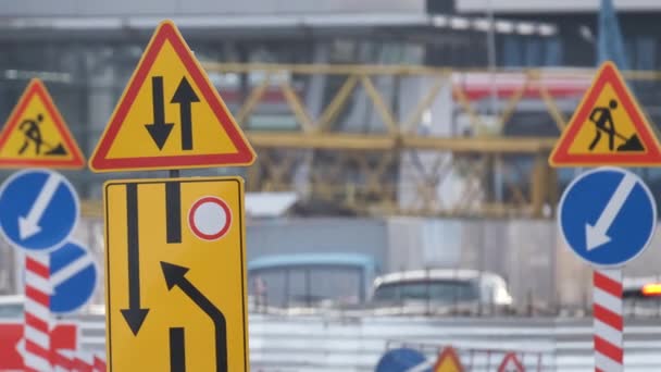 Roadworks warning traffic signs of construction work on city street and slowly moving cars — Stock Video
