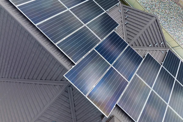 Gebouw vanuit de lucht dak met rijen blauwe fotovoltaïsche panelen voor het produceren van schone ecologische elektrische energie. Hernieuwbare elektriciteit zonder uitstoot — Stockfoto