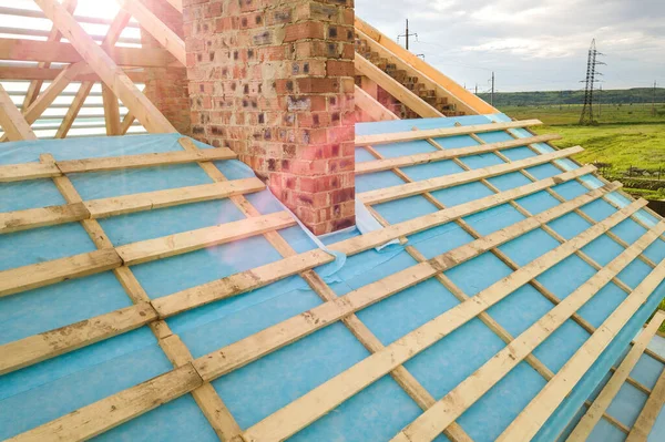 Вид с воздуха на кирпичный дом с деревянным каркасом крыши в стадии строительства — стоковое фото