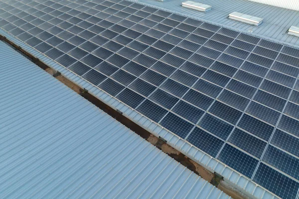 Vista aérea de paneles solares fotovoltaicos azules montados en el techo de un edificio industrial para producir electricidad ecológica verde. Producción del concepto de energía sostenible — Foto de Stock