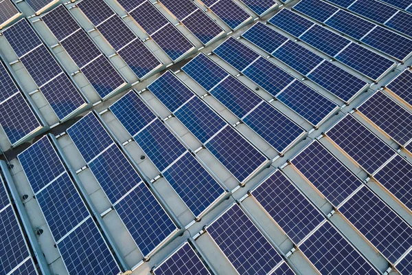 Aerial view of blue photovoltaic solar panels mounted on industrial building roof for producing green ecological electricity. 지속 가능 한 에너지 개념의 생산 — 스톡 사진