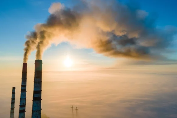 Uitzicht vanuit de lucht op hoge pijpen van kolencentrales met zwarte rook die bij zonsondergang de vervuilende atmosfeer opgaat — Stockfoto